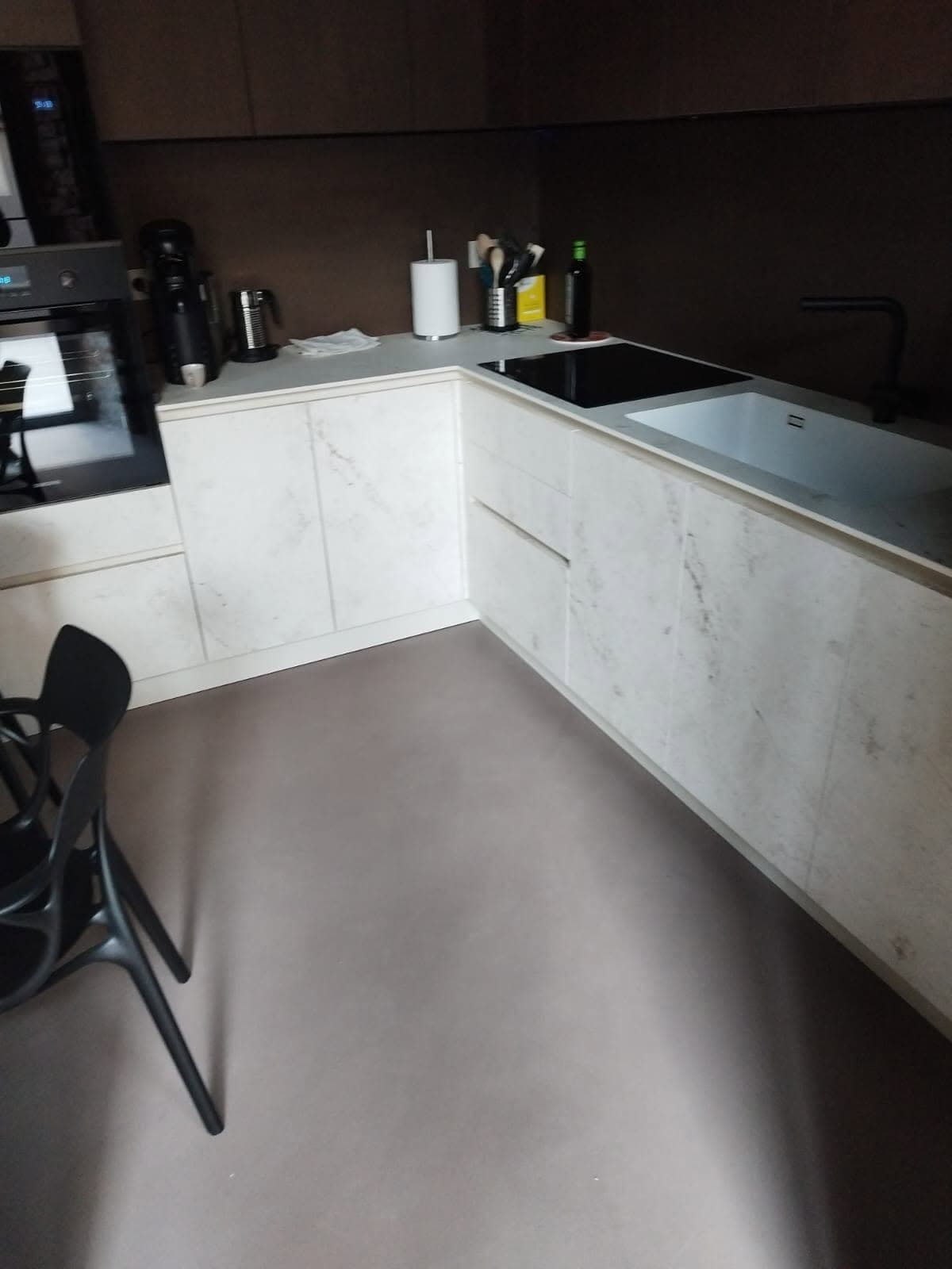 Cucina con pavimento continuo tortora e basi chiare