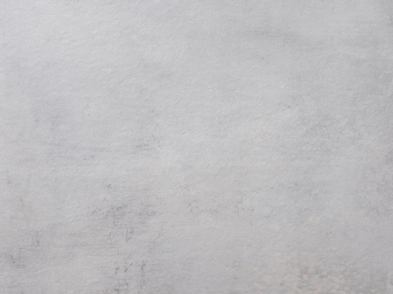 Dettaglio illustrativo di una superficie grigio chiaro con variazioni delicate