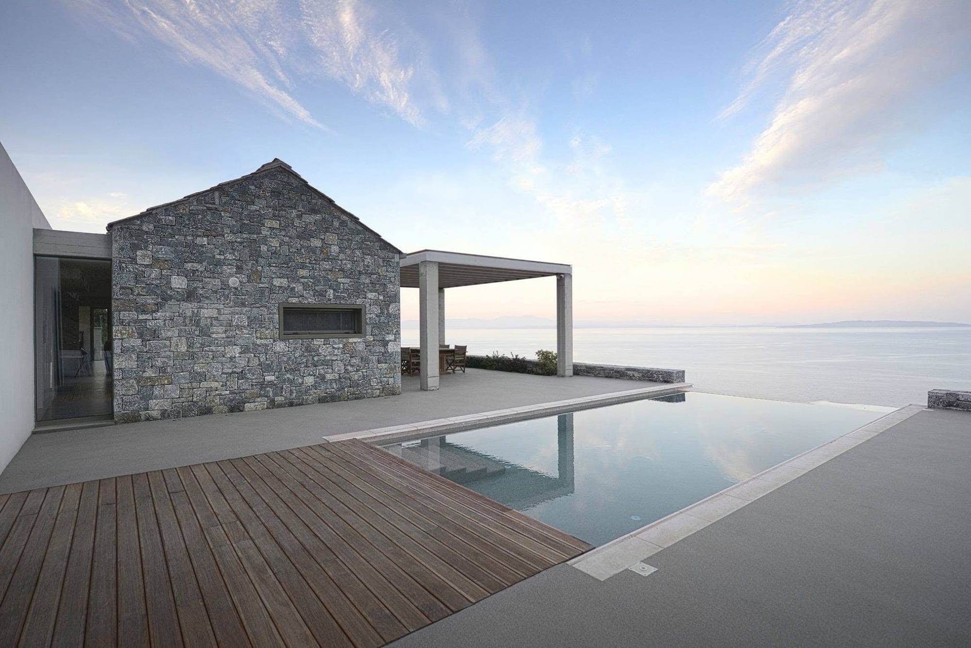 Architettura contemporanea con superficie continua esterna, legno e piscina