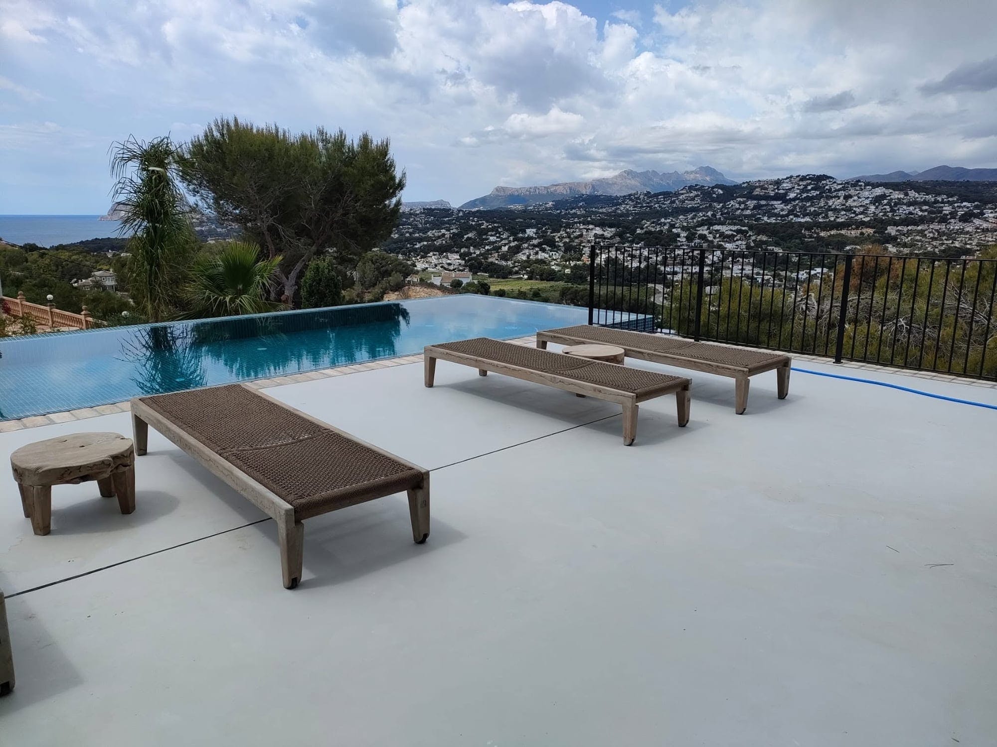 Terrazza contemporanea con superficie continua chiara accanto alla piscina