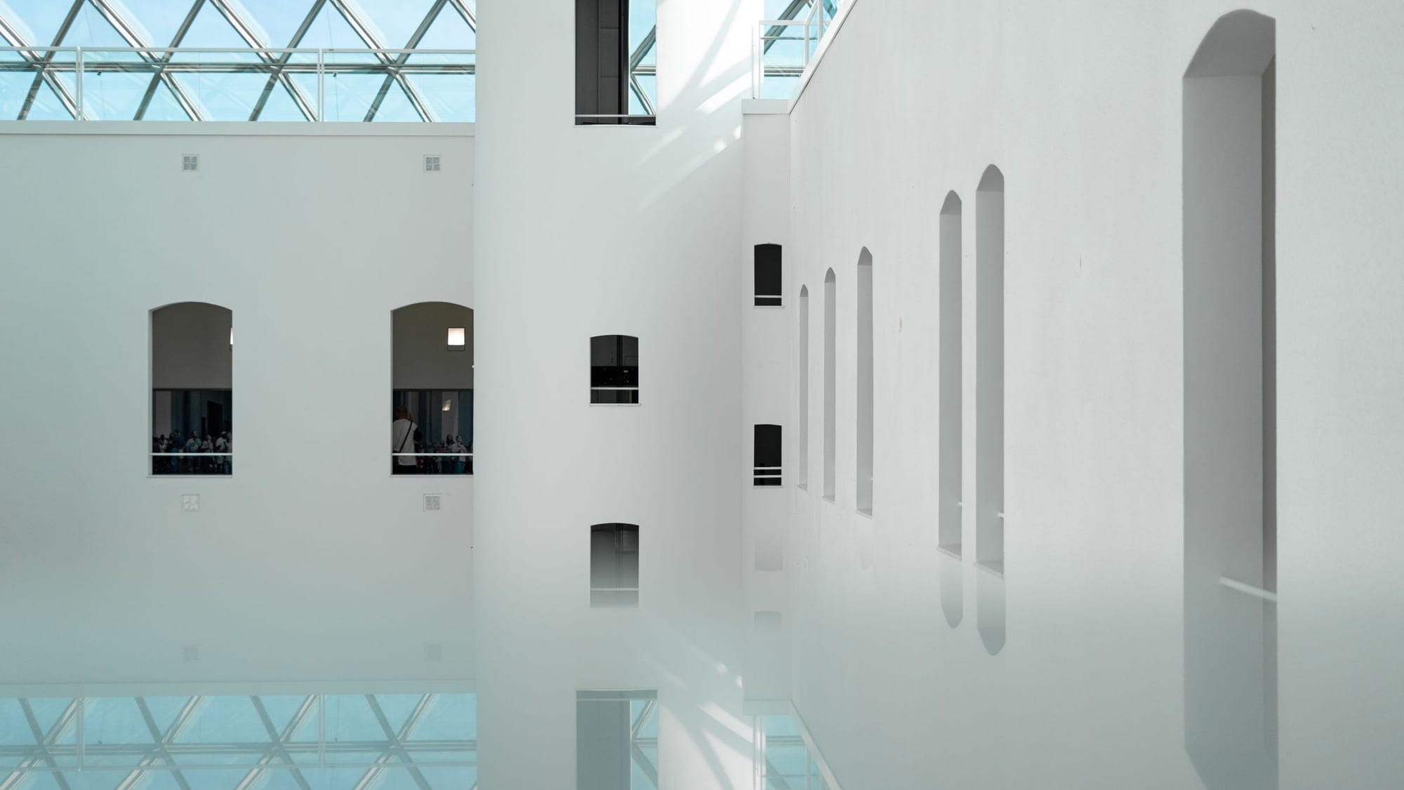 Spazio espositivo luminoso con pavimento continuo riflettente