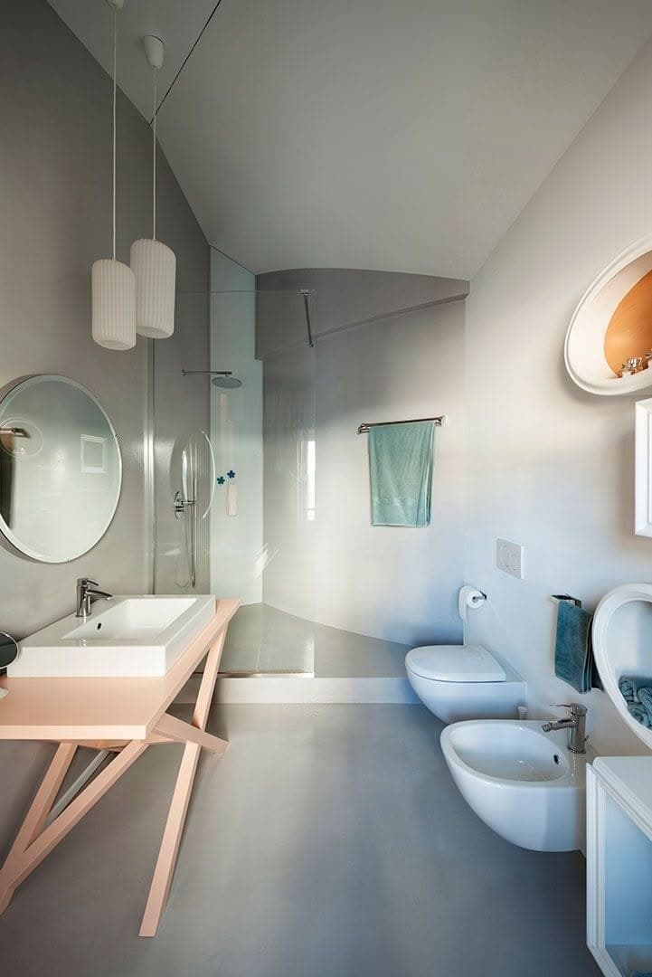 Seconda vista del bagno con rivestimenti continui, lavabo e sanitari