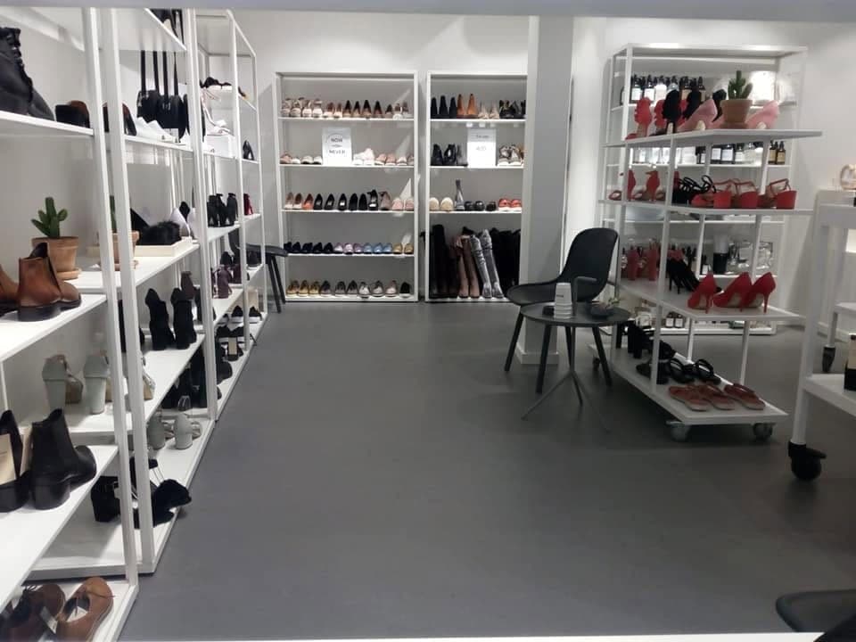 Spazio espositivo con pavimento continuo grigio e scaffali ordinati