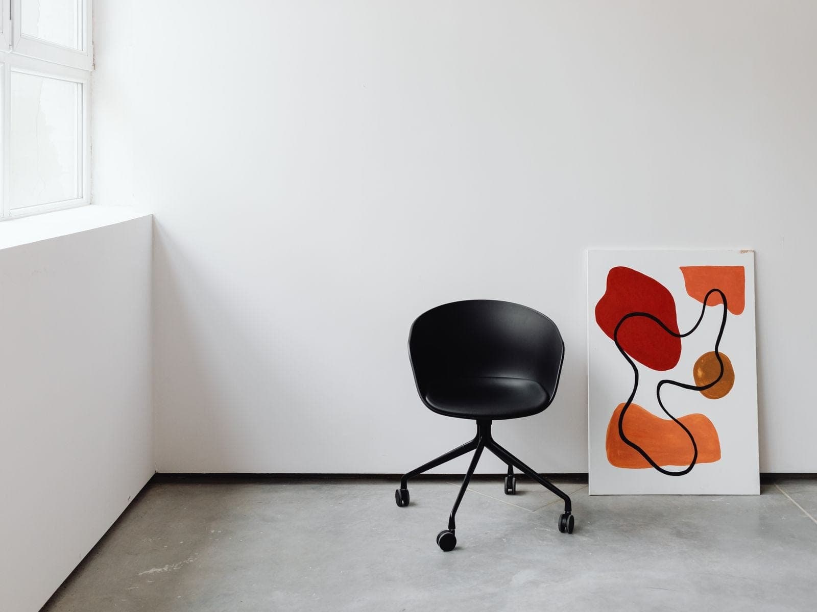 Angolo studio con pavimento continuo grigio chiaro e sedia